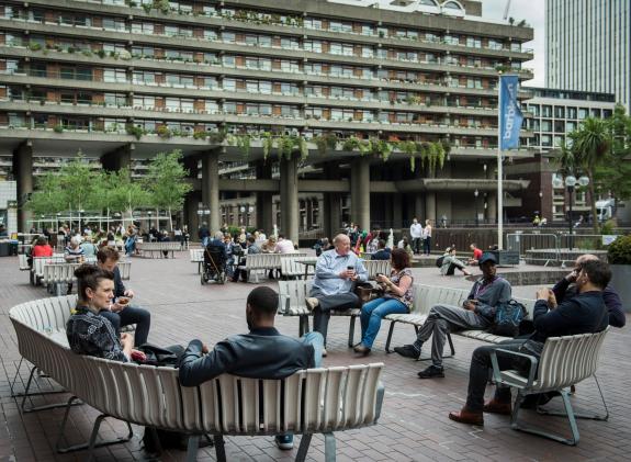People sitting on benches outside the Barbican