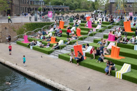 Londoners sitting outside on green steps