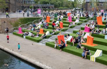 Londoners sitting outside on green steps