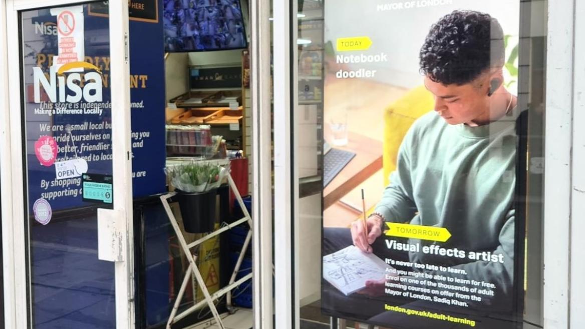 Poster in a shop window showing a young person doodling in a notebook, who may one day become a visual effects artist